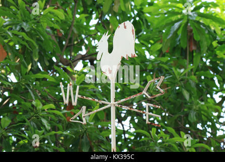 Weißen Hahn geformte Wetterfahne unter dem Laub, Thailand Stockfoto