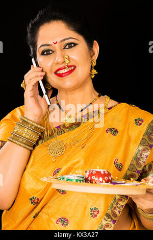 Indische Marathi Frau Diwali Festival sprechen Telefon mit Öllampen Stockfoto