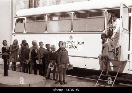Dieses Foto aus dem Jahr 1962 zeigt Studenten der dritten Klasse in Rače, Slowenien, die vor dem Einsteigen in einen Bus auf ärztliche Untersuchungen warten und veranschaulichen die Gesundheitsdienste der Schulen und die Praxis der Gesundheitsfürsorge in der Gemeinde. Stockfoto