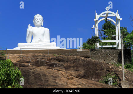 Große, weiße Statue des Buddha auf dem Felsen in Mihintale, Sri Lanka Stockfoto