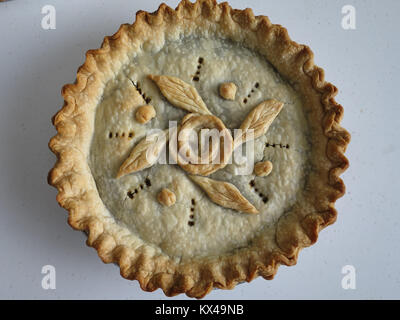 Traditionelle Hackfleisch Torte mit ausgefallenen Kruste und Dekoration für Weihnachten Mahlzeit vorbereitet. Rose pattern von piecrust kommt gebildet, und geriffelten Rand. Stockfoto