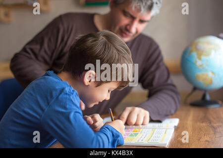 Kaukasische Vater und Sohn tun, Mathematik Hausaufgaben am Schreibtisch Stockfoto