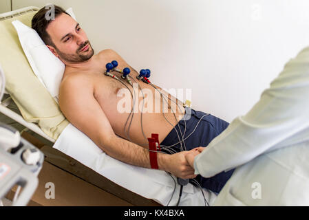 Junger Mann tun präventiven EKG im Krankenhaus Stockfoto