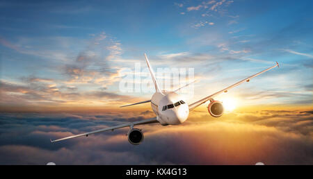 Commercial Airplane Flugzeug über den Wolken im schönen Abendlicht fliegen. Reisen und Business Konzept Stockfoto