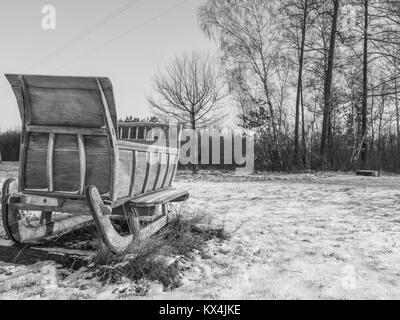 Große hölzerne Schlitten auf einem schneebedeckten Feld Stockfoto