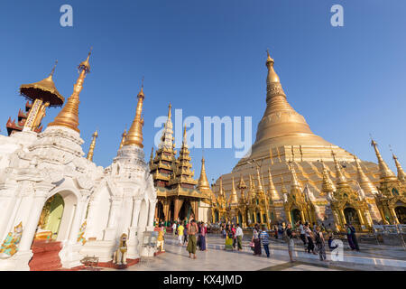 Eine Menge Leute vor der vergoldeten Shwedagon Pagode in Yangon, Myanmar, an einem sonnigen Tag. Stockfoto