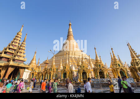 Eine Menge Leute vor der vergoldeten Shwedagon Pagode in Yangon, Myanmar, an einem sonnigen Tag. Stockfoto