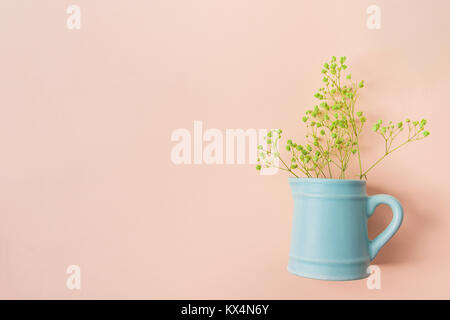 Kleinen Strauß gelber Akazienblüten in Vintage Keramik blaue Kanne auf Rosa Hintergrund. Flach Kreativ. Website Banner Vorlage. Kopieren Raum Ostern M Stockfoto