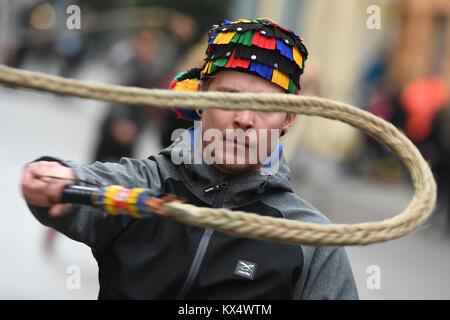 Überlingen, Deutschland. 6. Januar, 2018. Eine Fasnacht Narren schwingt eine so genannte "karbatsche", Peitsche ist ein traditionelles Narr, als Hunderte von Zuschauern auf während die traditionelle alemannische Fasnacht feiern in Überlingen, Deutschland, am 6. Januar 2018. Fasnact ist ein traditioneller Karneval Feier, die in West- und Süd-West-Deutschland gefeiert wird. Credit: Felix Kästle/dpa/Alamy leben Nachrichten Stockfoto