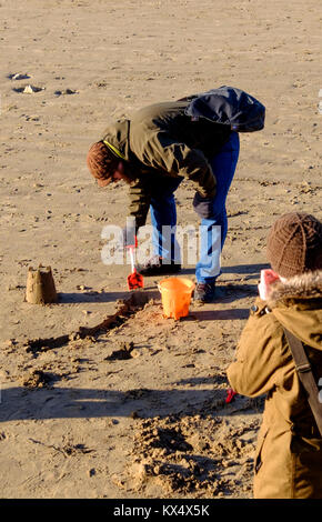 Weston-super-Mare, Großbritannien. 07 Jan, 2018. 7. Januar 2018. Ein junges Paar trotzen dem-5C Wind chill Sandburgen am Strand von Weston zu machen. ©Alamy Live News/JMF-News Credit: Herr Standfast/Alamy leben Nachrichten Stockfoto