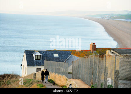 Isle of Portland, Großbritannien. 7. Januar 2018 - Ein paar Spaziergang mit ihrem Hund den steilen Pfad zu Chesil Beach, als Bitterkalten Tag in Portland geht zu Ende Quelle: stuart Hartmut Ost/Alamy leben Nachrichten Stockfoto