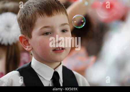 Belarus, Gomel, 3. Juni 2016. Abschlussfeier im Kindergarten. ein Kind in einer Seifenblase. Einen bewundernden Blick. Um zu sehen, ein Wunder. Die Schönheit bewundern. Stockfoto