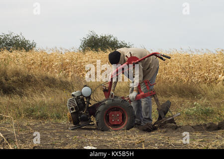 DIKANKA, UKRAINE - 30. SEPTEMBER 2015: Land Landwirt pflügt seinen Garten mit Garten hinter dem Traktor. Stockfoto