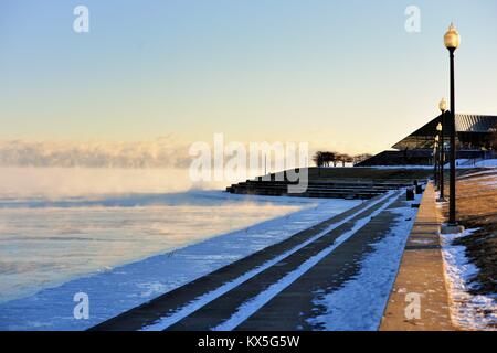 Wind und Kälte mit Windchill Faktoren von mehr als minus 20 Grad Dampf über dem Eis in Michigan See gebildet. Chicago, Illinois, USA. Stockfoto