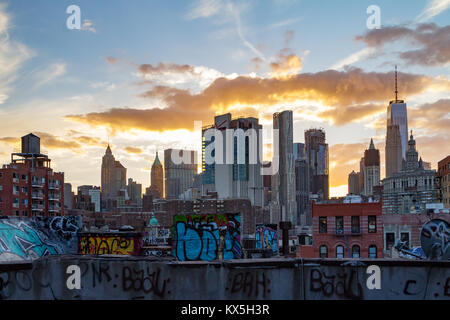 NEW YORK CITY - ca. 2017: Graffiti deckt die Dächer der Gebäude in Chinatown mit den bunten Sonnenuntergang im Hintergrund des Manhattan sky Stockfoto