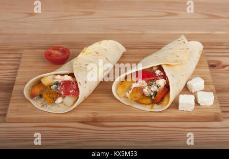 Tortilla Wraps mit Hähnchenfleisch, Tomaten, Pommes frites und Feta, traditionelle griechische fast food genannt Souvlaki oder Gyros in Pita. Stockfoto