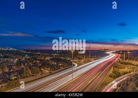 Night Shot von Highway 401 North York, Toronto, während der Dämmerung. Helle Streifen von bewegten Fahrzeugen Stockfoto