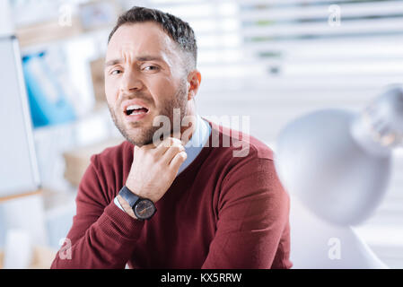 Emotionale Arbeitnehmer berühren seinen Hals und Halsschmerzen Stockfoto