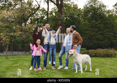 Gerne große Familie mit Labrador Retriever Hund spielen im Park Stockfoto