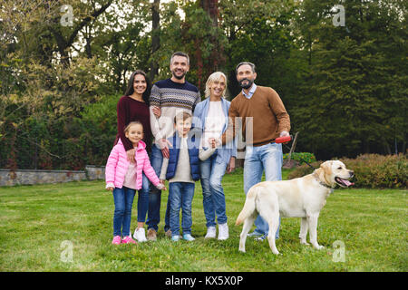 Schöne große glückliche Familie ist Spaß mit Golden Retriever im Freien Stockfoto