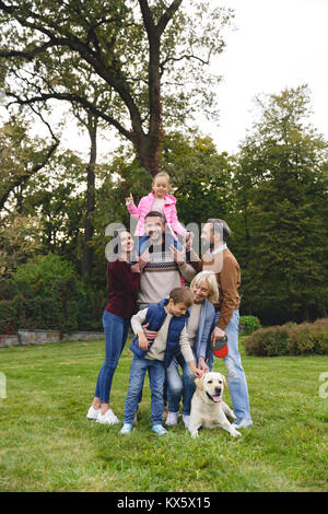 Schöne große glückliche Familie ist Spaß mit Golden Retriever im Freien Stockfoto