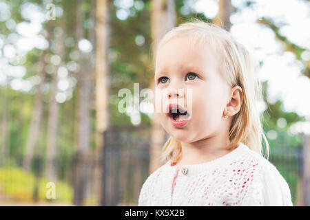 Bild der süssen Baby Mädchen weg von der Kamera mit der Mund vor Staunen offen. Nahaufnahme, Porträt eines Kindes. Niedliches Kleinkind mit grünen Augen portrait. Stockfoto