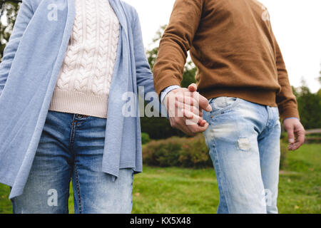 Zugeschnittenes Bild von Reifes Paar Hände halten während sie gemeinsam im Freien Stockfoto