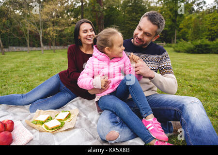 Glückliche junge Familie mit Picknick im Freien Stockfoto