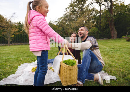 Gerne kleine Mädchen, Picknickkorb zu ihrem Vater im Freien Stockfoto