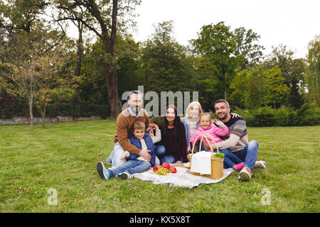 Große, glückliche Familie mit Picknick im Freien zusammen Stockfoto