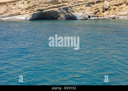 MATALA BAY, KRETA, GRIECHENLAND - 1. Mai: Paar schwimmen im Mittelmeer bei Matala auf Kreta, die am 1. Mai 2010. Matala ist einer der am meisten Wunder Stockfoto