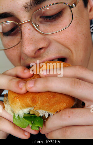 Mann isst einen hamburger Stockfoto