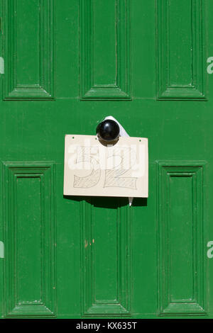 Haus Nummer 52 Zeichen auf Karton und hängende Form Türklopfer gezeichnet Stockfoto