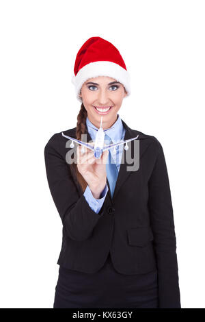 Lächelnde Stewardess mit Weihnachtsmütze Holding Ebene, auf weißem Hintergrund Stockfoto