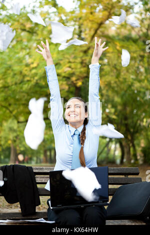 Glück Geschäftsfrau werfen Papier in der Luft, im Freien Stockfoto