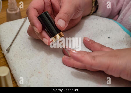 Eine Nahaufnahme der Hände eines Dame, als sie malt ihr der Nägel mit Nagellack. Stockfoto