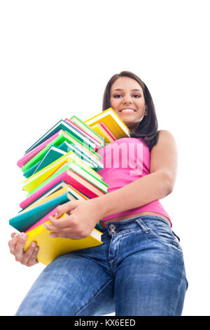 Lächelnde Mädchen Holding groß von Farbe Stapel Bücher und nach unten schauen, auf weißem Hintergrund Stockfoto