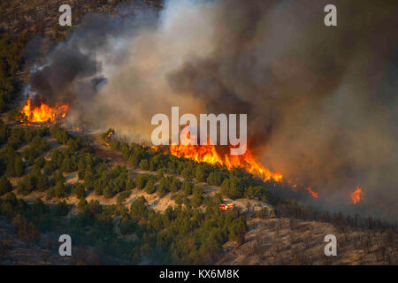 Utah National Guard Loslösung 2, Unternehmen C, 1. Allgemeine Unterstützung Aviation Battalion, 171St Aviation Regiment von West Jordan, Utah, führt die Wassertropfen mit einem "Bambi Bucket' auf ein wildfire auf Utah Training Center Camp Williams, Tennessee, 6. Aug 2012. Bambi Schaufeln sind ein Handel gekennzeichneten Namen für faltbarer Eimer Wasser durch SEI Industries, einem kanadischen Unternehmen gemacht. Sie können dump 660 Gallonen Wasser in ein Feuer in einer Zeit. (U.S. Air Force Foto von Tech. Sgt. Dennis Henry jr./Freigegeben) Stockfoto