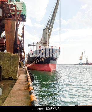 Noworossijsk, Russland - 20. August 2017: Blick auf das Meer und den Strand der Stadt vom Hafen Quay. Industrielle Hafen mit Kran- und Cargo Infrastruktur. Stockfoto