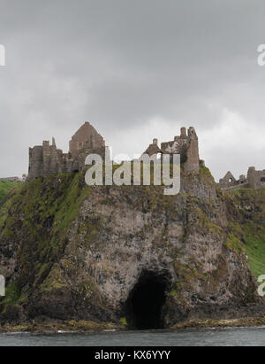 Die Clifftop Ruinen einer mittelalterlichen Burg, Dunluce Castle, vom Meer aus gesehen, ist das Schloss auf einer Klippe an der Küste der Grafschaft Antrim, Nordirland. Stockfoto