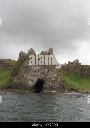 Die Clifftop Ruinen einer mittelalterlichen Burg, Dunluce Castle, vom Meer aus gesehen, ist das Schloss auf einer Klippe an der Küste der Grafschaft Antrim, Nordirland. Stockfoto