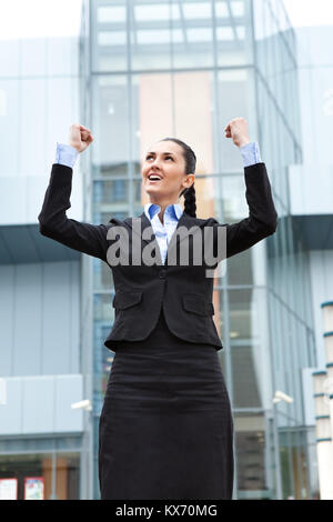 Geschäftsfrau stehen im Freien feiern ihren gewinnenden, Front Office Building Stockfoto