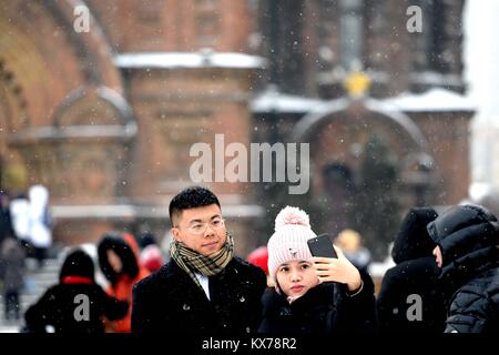 (180108) - HARBIN, Januar 8, 2018 (Xinhua) - Touristen posieren für ein Foto bei Saint Sophia Kathedrale in Harbin, der Hauptstadt der Provinz Heilongjiang im Nordosten Chinas, Jan. 8, 2018. Die Stadt der erste Schnee in diesem Winter am Montag begrüßt. (Xinhua / Wang Kai) (zkr) Stockfoto