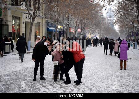 (180108) - HARBIN, Januar 8, 2018 (Xinhua) - Touristen posieren für Fotos, die auf der zentralen Straße von Harbin, der Hauptstadt der Provinz Heilongjiang im Nordosten Chinas, Jan. 8, 2018. Die Stadt der erste Schnee in diesem Winter am Montag begrüßt. (Xinhua / Wang Kai) (zkr) Stockfoto