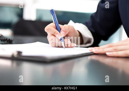 Woman's Hand mit Stift Unterzeichnung Dokument, das in der Nähe Stockfoto