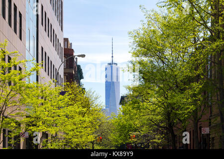 New York City Szene auf Bäumen gesäumten Thompson Street in Greenwich Village mit einem Downtown Manhattan Wolkenkratzer Turm im Hintergrund Stockfoto