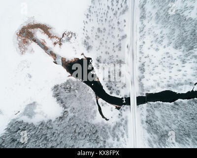 Luftaufnahme von Schwarzen Fluss bewässert, vereisten See und borealen Wäldern mit einer Kreuzung der Rahmen Stockfoto