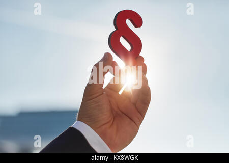 Hand hält Absatz Zeichen in der Sonne als Symbol für die Idee des Gesetzes Stockfoto