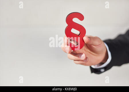 Hand hält eine Ziffer als Zeichen der Gerechtigkeit und Recht und Gesetz Stockfoto