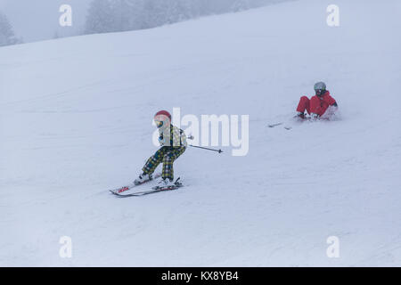 Kinder Ski und Spaß auf der Piste im Schnee und Nebel Skrzyczne Berg in Szczyrk eine der polnischen Krone Spitzen im Schlesischen Beskiden abgedeckt Stockfoto